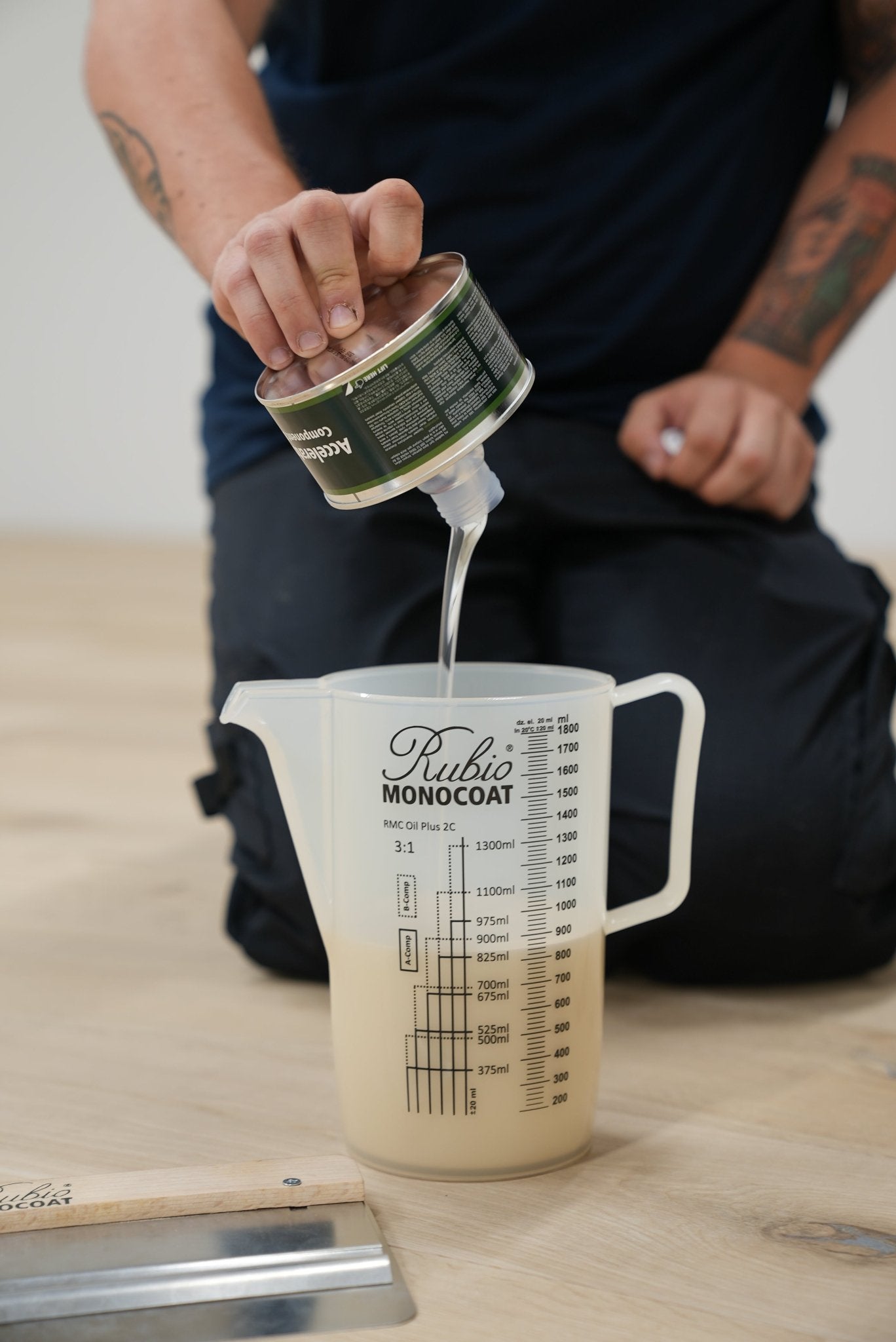 Person pouring Rubio Monocoat Accelerator into a measuring cup.